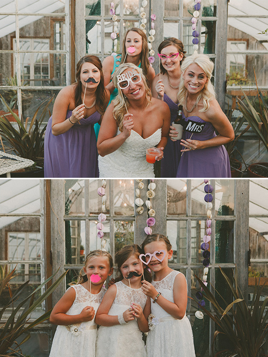 Bridesmaids and flower girls pose with photo booth props