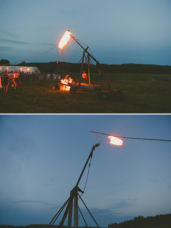 A trebuchet launches fire at a nighttime celebration