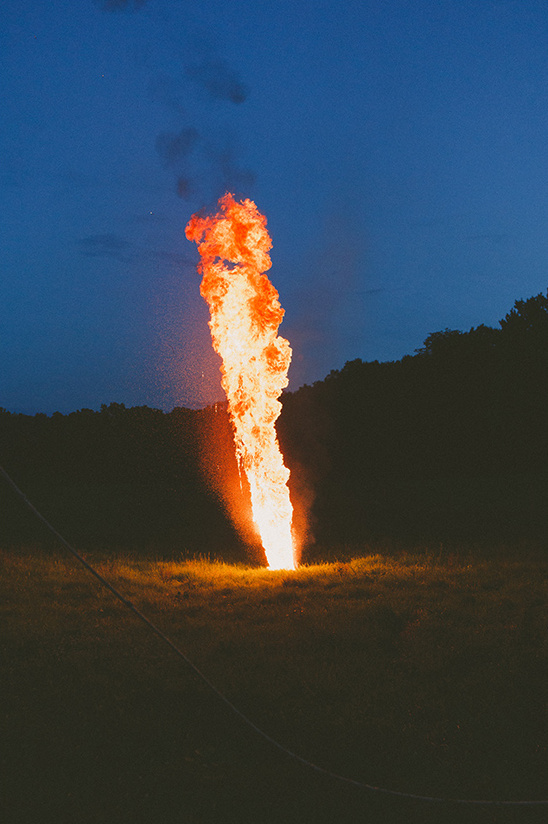 Towering flame burns brightly against the night sky
