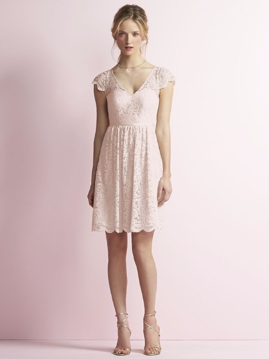 Blonde woman in a light pink lace dress, standing gracefully