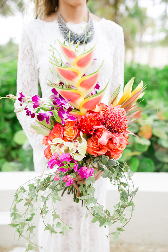 Woman with vibrant tropical flower bouquet in white dress