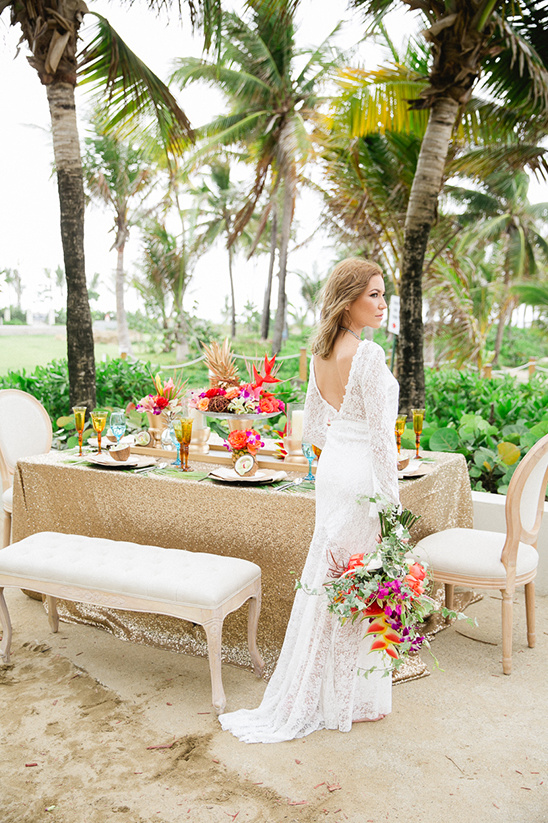 Bride at tropical beach wedding reception with bright flowers