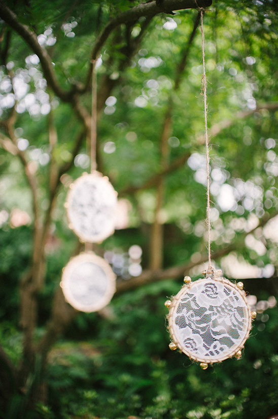 Lace dream catchers hanging from a tree for outdoor wedding decor