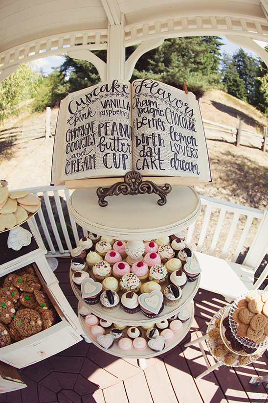 Wedding cupcakes with a flavor menu on a tiered display