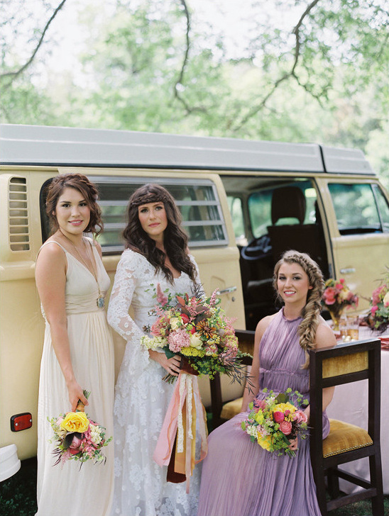 Three boho bridesmaids posing at a rustic outdoor wedding