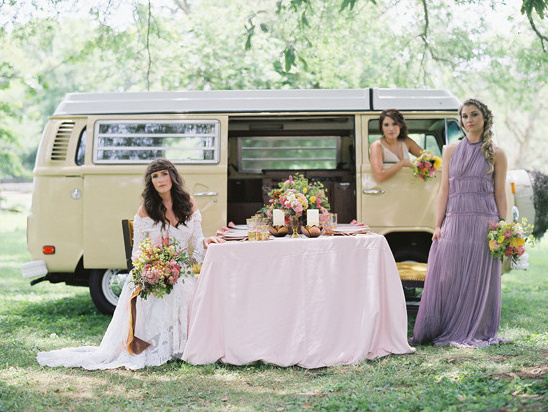 Bohemian bride with bridesmaids near a vintage camper van, celebration