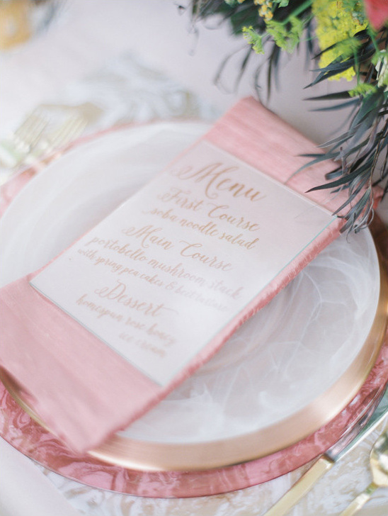 Elegant table setting with a menu on a pink napkin and plate