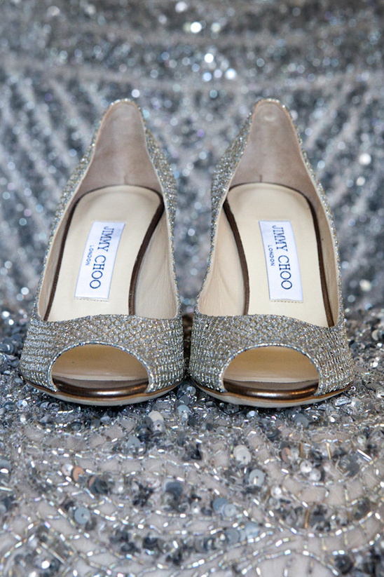 Jimmy Choo sparkling silver peep-toe high heels on a silver bed