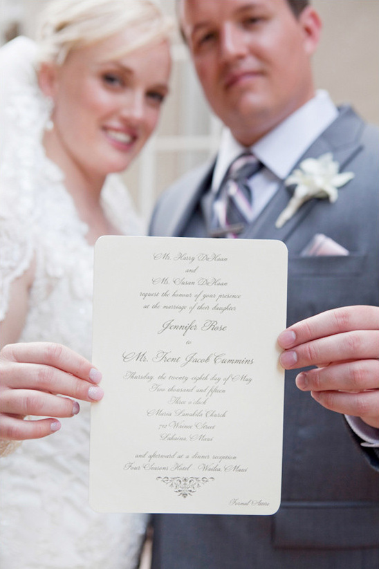 Bride and groom holding a wedding invitation, ready to get married