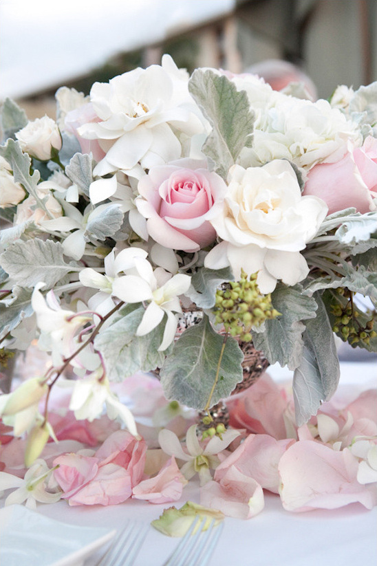 Elegant floral centerpiece with white and pink roses and petals