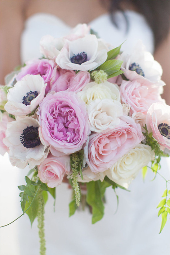 Bride holding a bouquet of pink and white anemone roses
