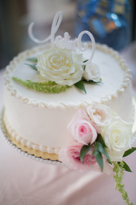 Elegant wedding cake topped with roses and love sign