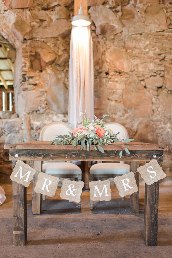 Rustic wedding table with floral arrangement and MR and MRS banner