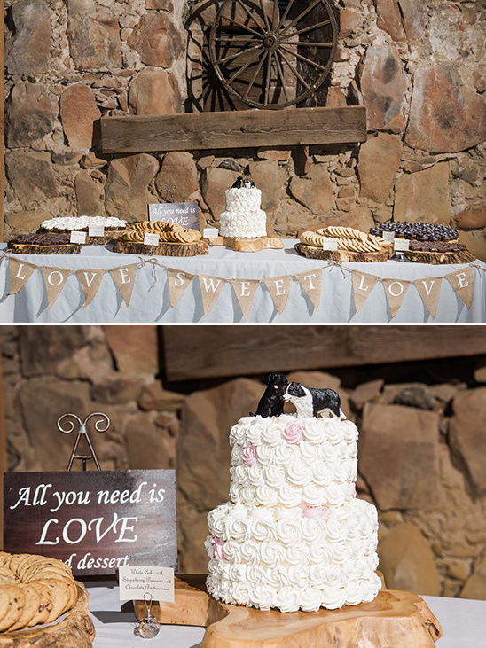 Rustic wedding dessert table with cake, love banner, and treats