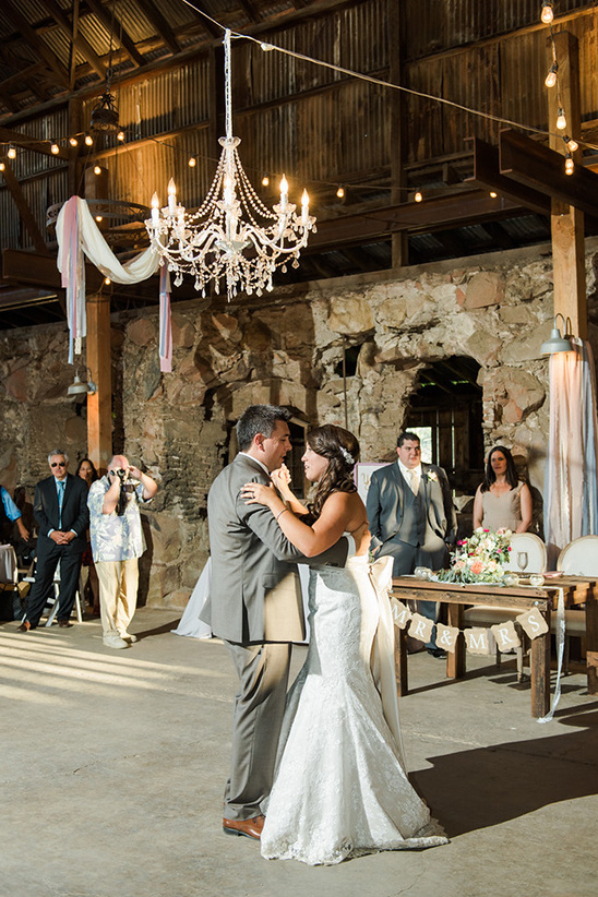 Bride and groom dancing their first dance at a barn wedding reception