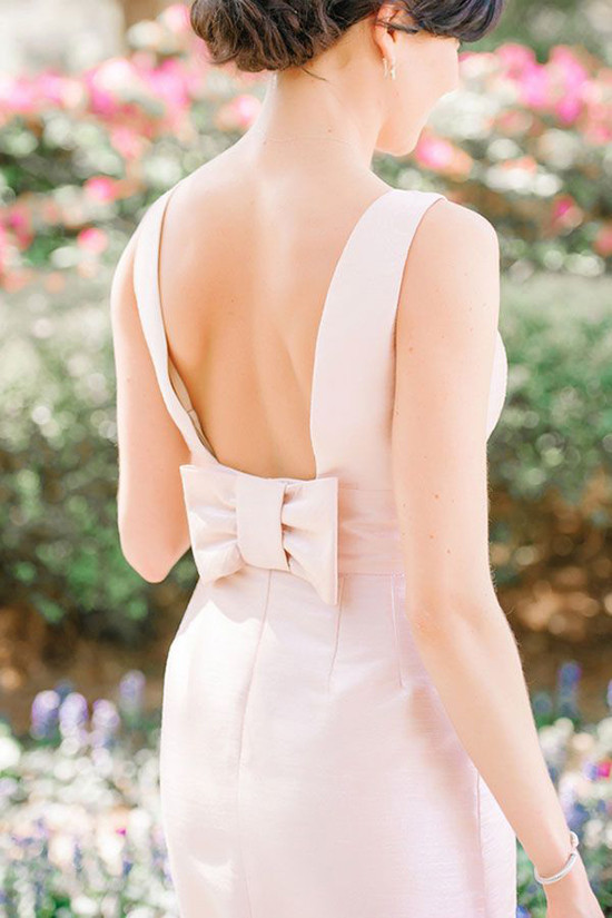 Woman in pink dress with bow detail at back