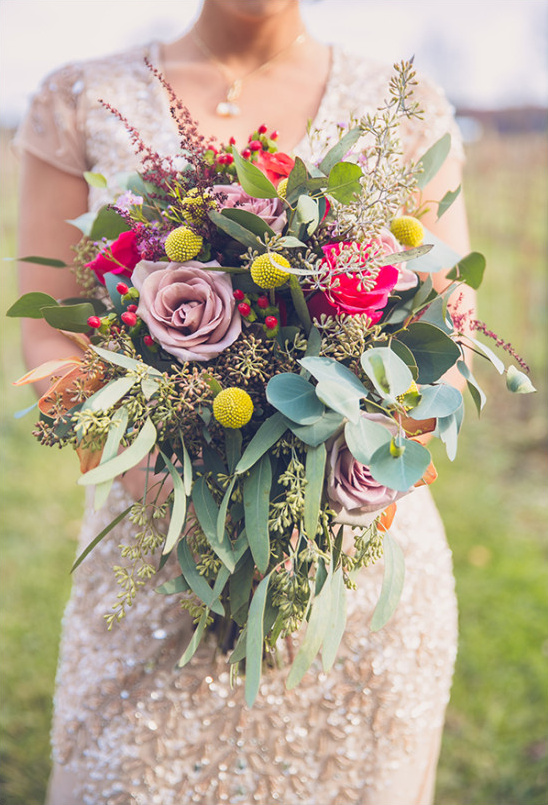Bride holds a colorful wedding bouquet of roses