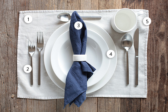 Formal place setting with white plates and blue napkin