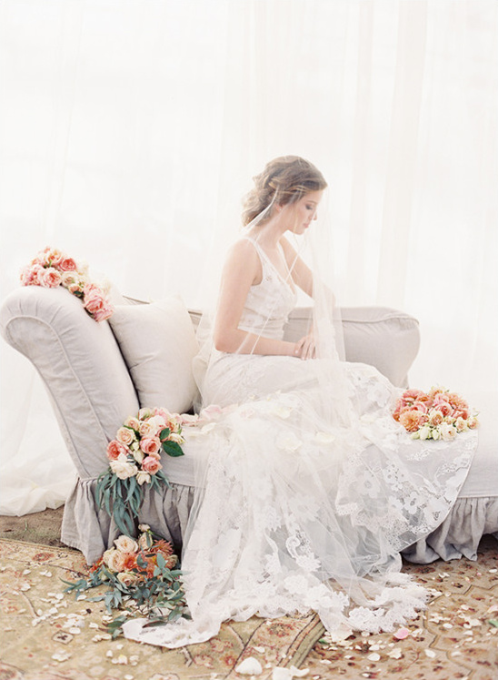 Elegant bride in flowing lace wedding dress with flowers