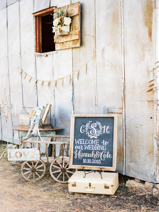 Rustic barn wedding decor welcome sign and vintage cart
