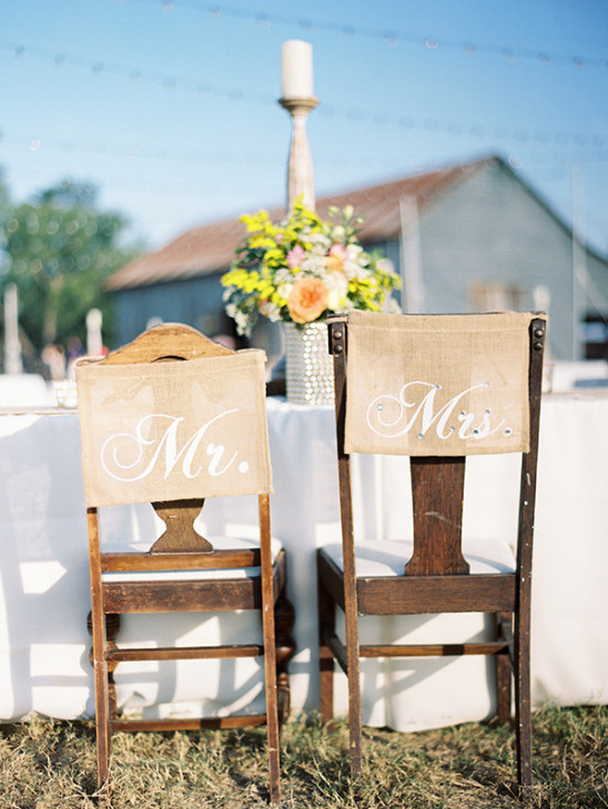 Rustic wedding reception chairs with Mr and Mrs signs