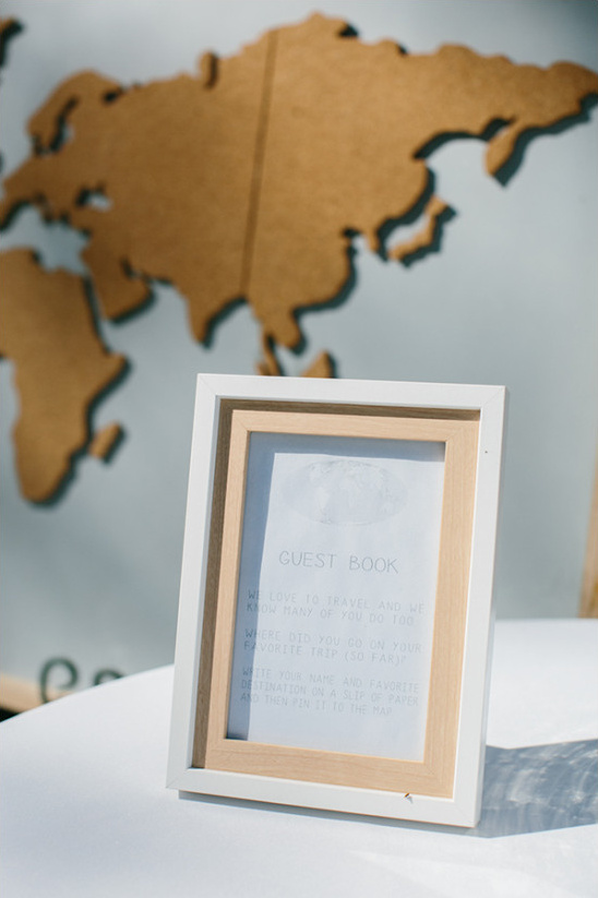 White framed guest book sign near world map
