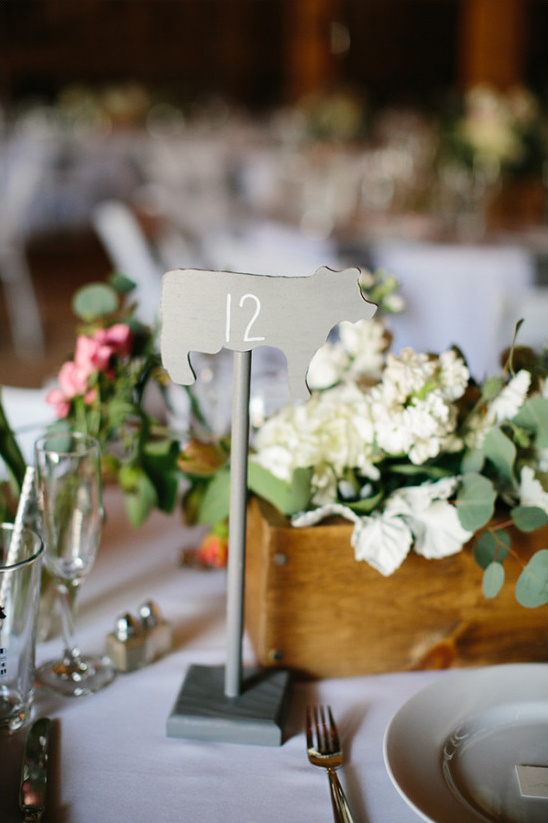 Table number twelve cow decor at a rustic wedding reception