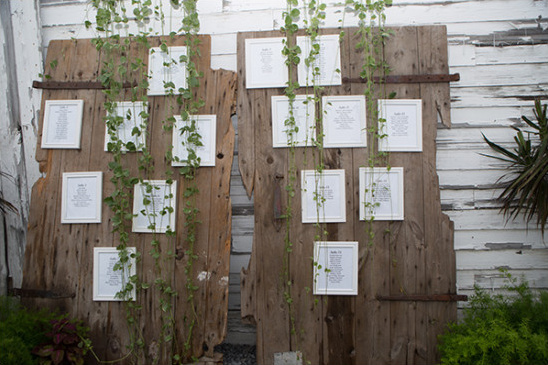 Wedding seating chart on rustic wooden doors with vines