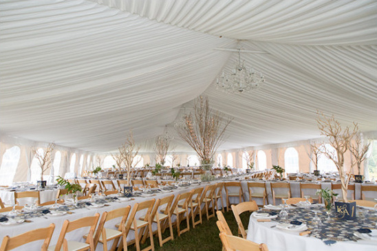 Elegant white tented wedding reception with tables