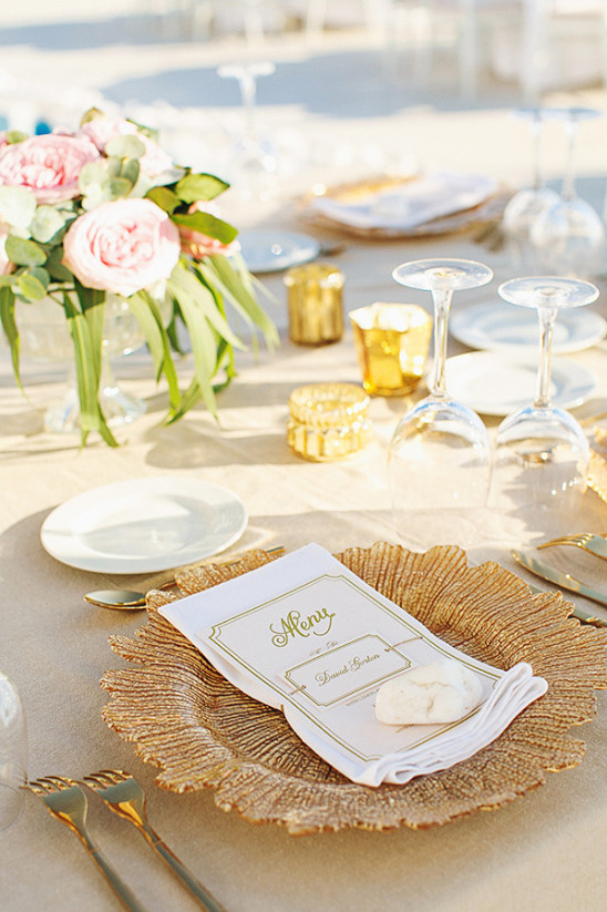 Elegant wedding table setting with gold charger and menu