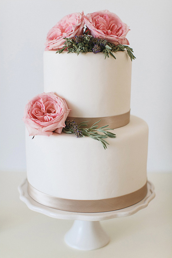 Two tier cake with pink roses and ribbon detail