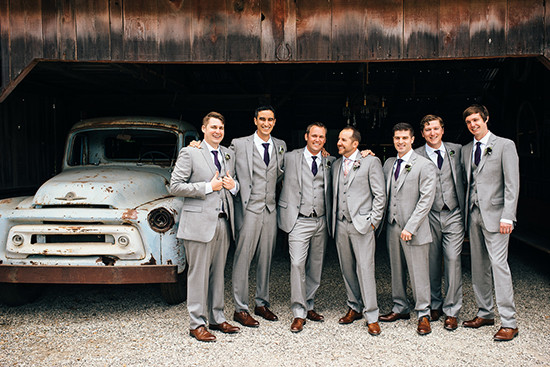 Groomsmen in suits with vintage truck at wedding venue