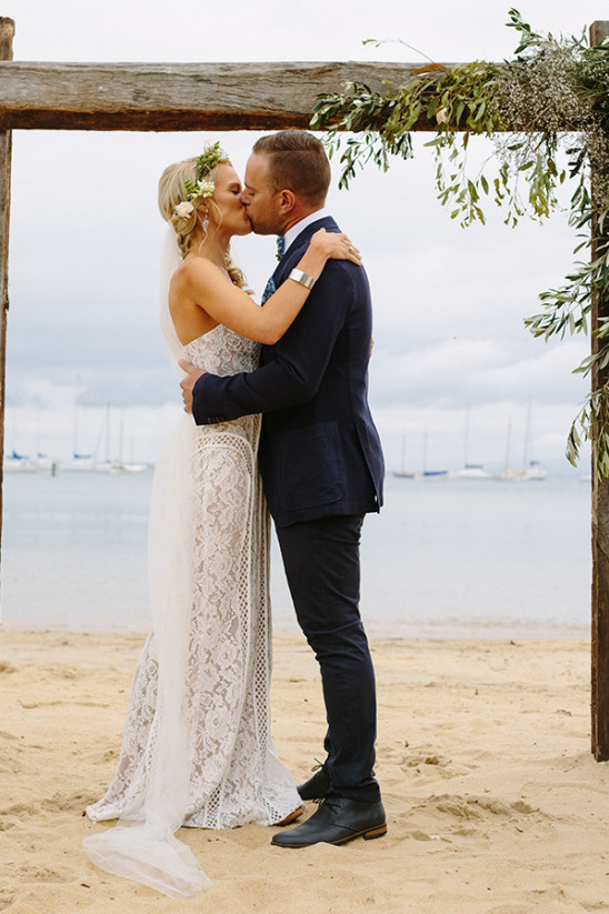 Bride and groom share kiss at beach wedding ceremony