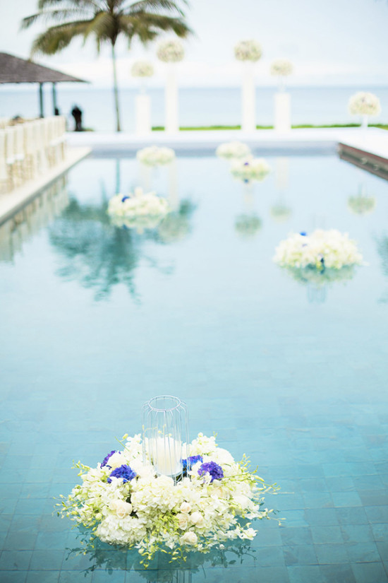 white and blue floating flower arrangements for pool side wedding