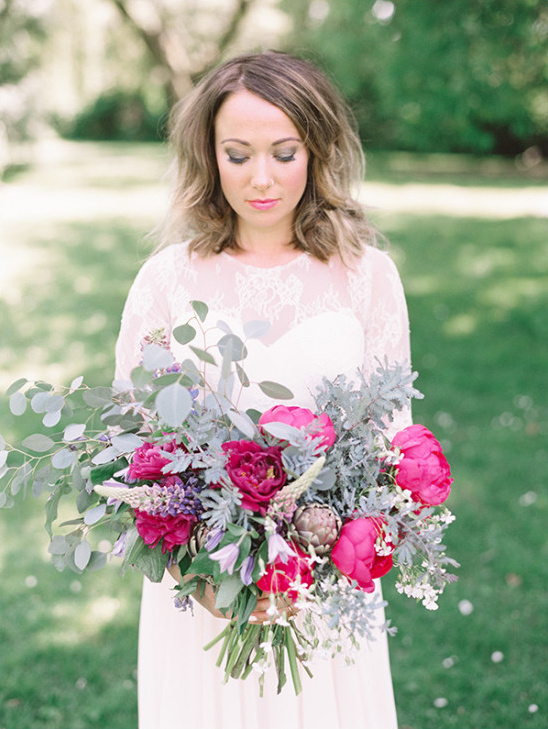 Bride in white dress holding a colorful flower bouquet