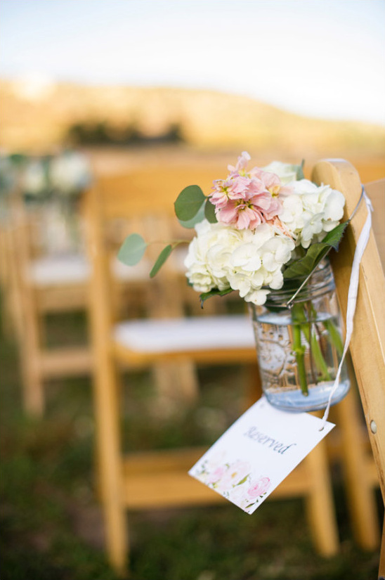 Reserved chair decorated with flowers for outdoor wedding