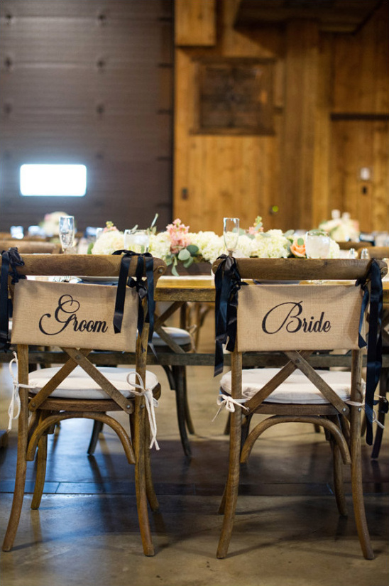 Bride and groom chairs decorated at wedding venue