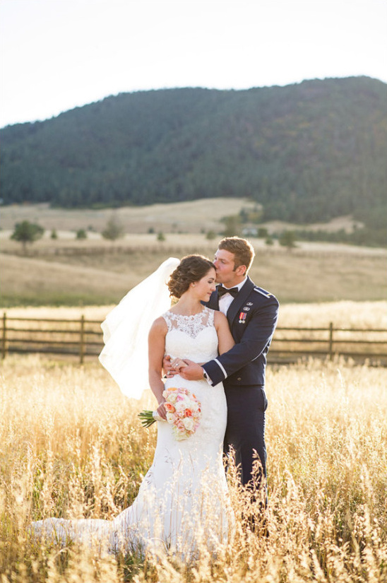 Bride and groom in field at military wedding
