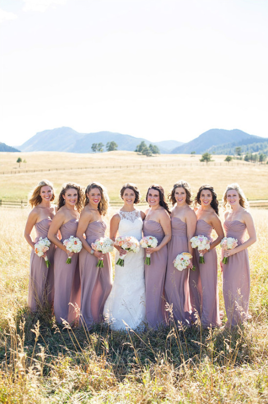 Bride and bridesmaids in mauve dresses outdoors