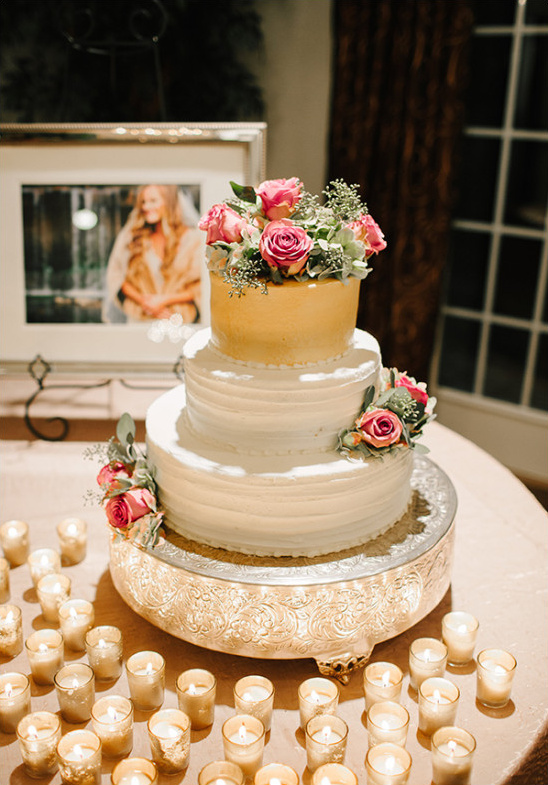 Three tier wedding cake with roses and candles