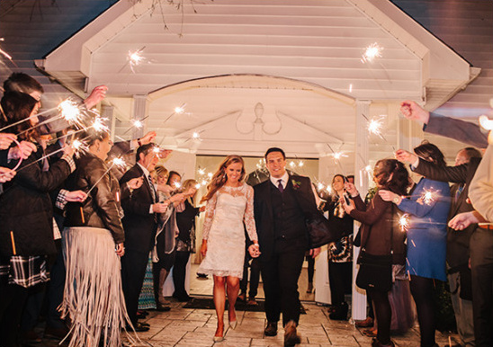 Bride and groom exit wedding with sparklers aglow