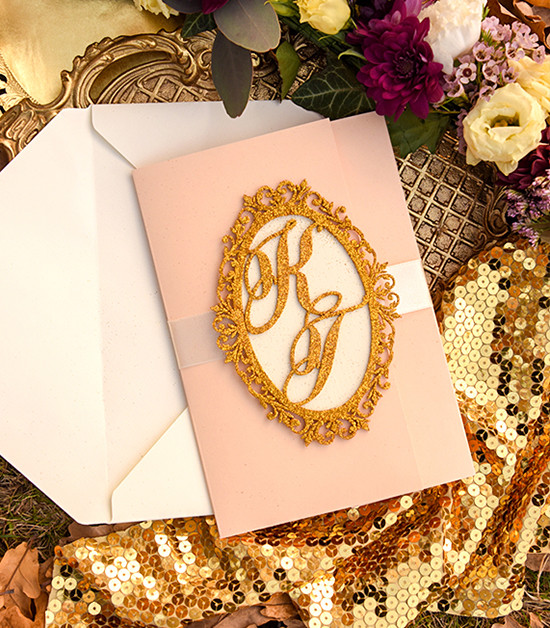 Elegant blush wedding invitation with gold monogram