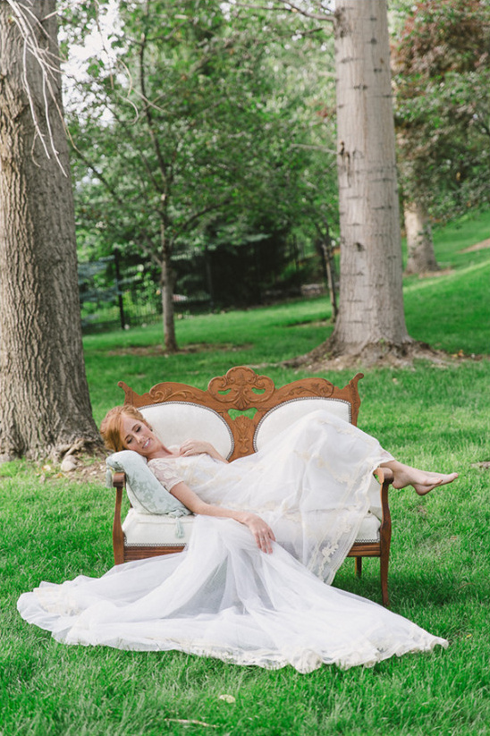 Bride relaxing in wedding dress on couch outdoors