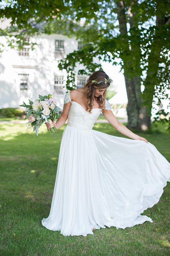 Bride in flowing white gown holding bouquet outdoors
