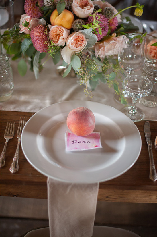 Elegant wedding place setting with peach and floral centerpiece