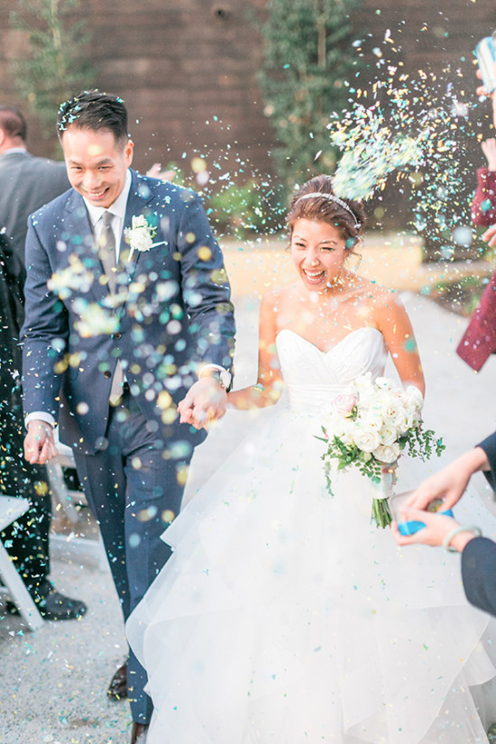 Happy newlyweds showered in confetti