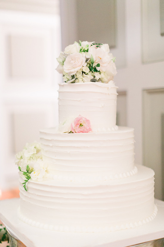 Elegant three-tiered wedding cake with white roses