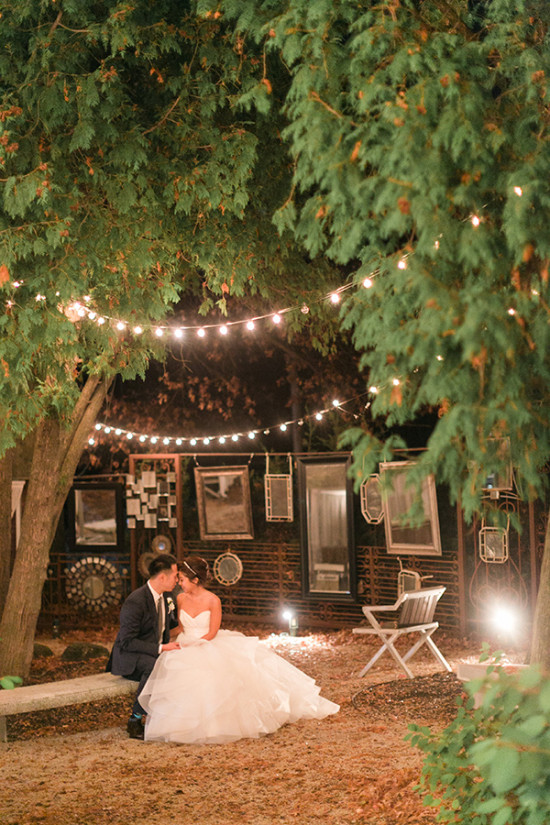Newlywed couple embracing under fairy lights