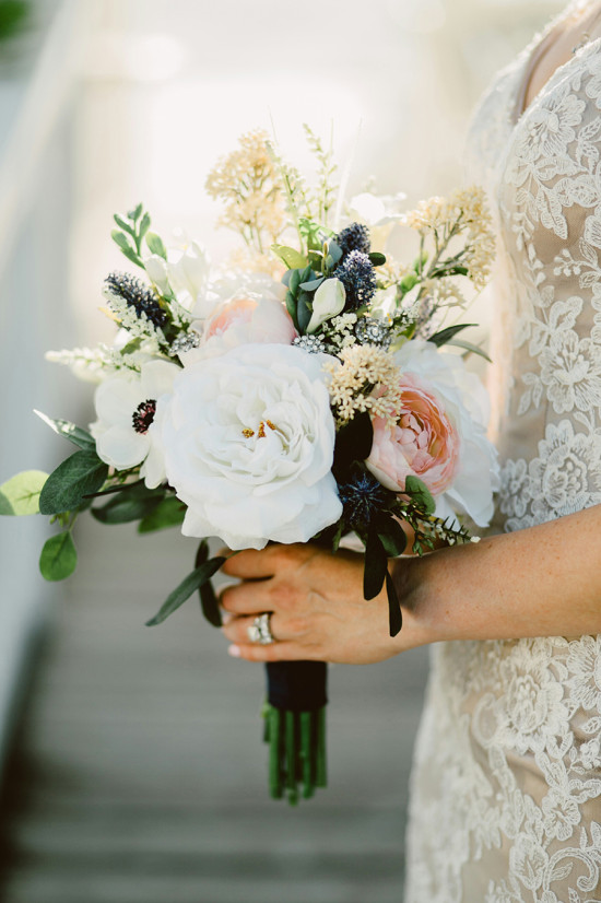 Bride holds white and peach wedding bouquet flowers