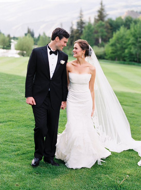 Bride and groom stroll holding hands on wedding day